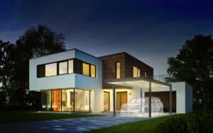 Maison moderne éclairée le soir avec carport et esquisse d'un SUV. Architecture blanche et bois.